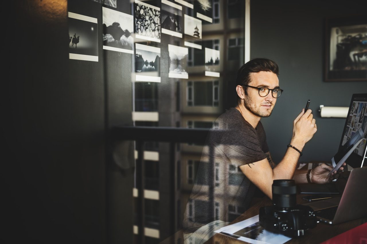 Hombre sentado trabajando en edición de imagenes digitales