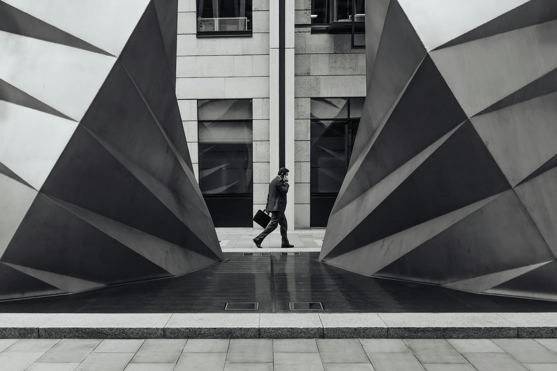 Imagen de un hombre de negocios caminando frente a una fuente en blanco y negro